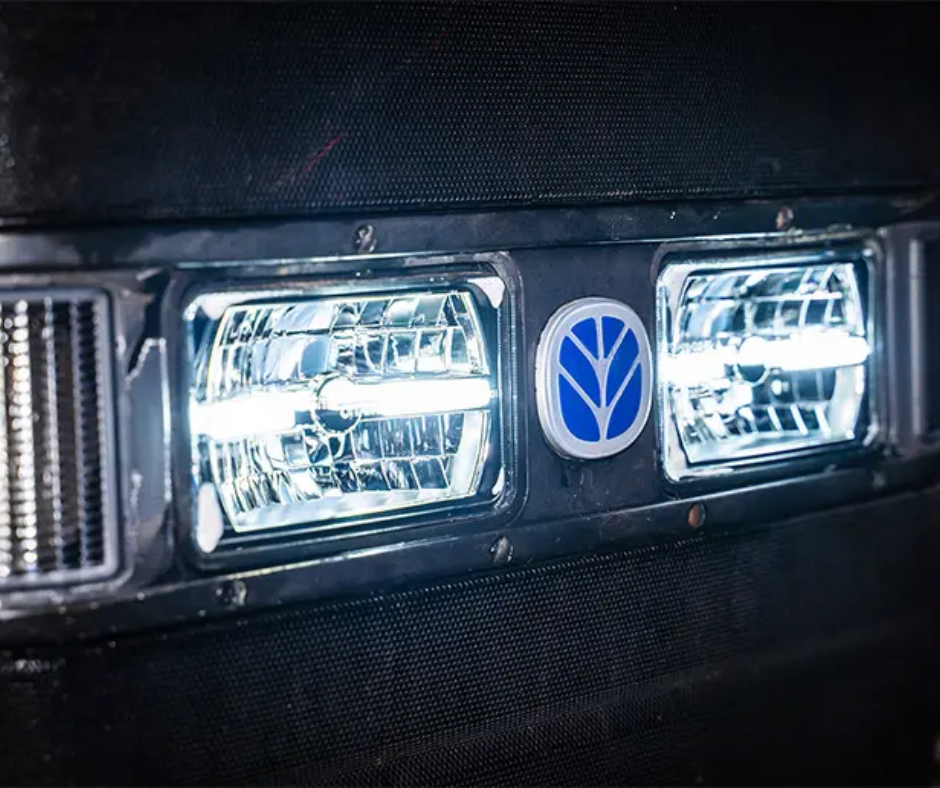 Car headlight with a visible brand logo on a dark background