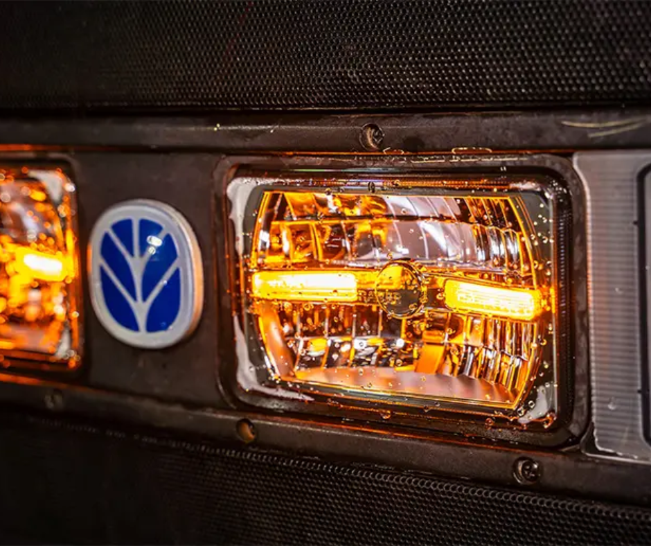 Close-up of a vehicle's headlight with a visible brand logo.