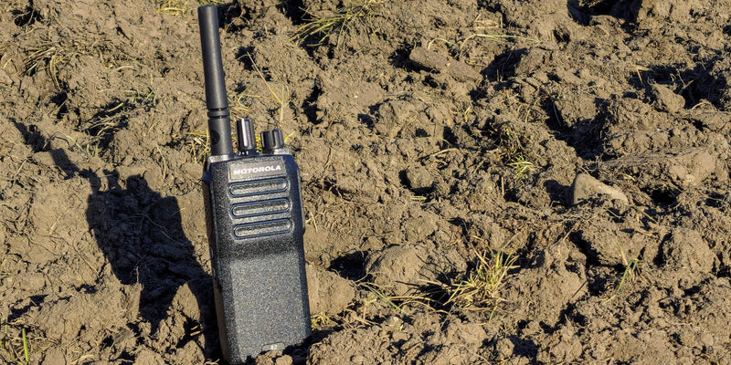 Black walkie-talkie on a muddy ground