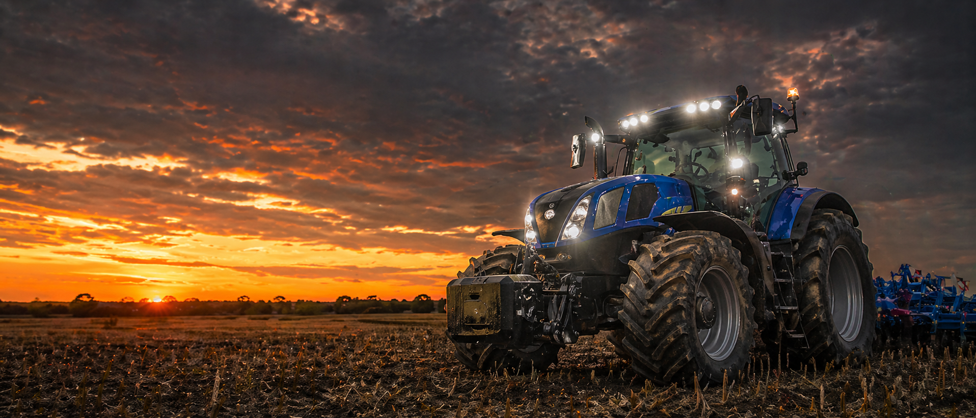 Tractor in a field with a sunset sky