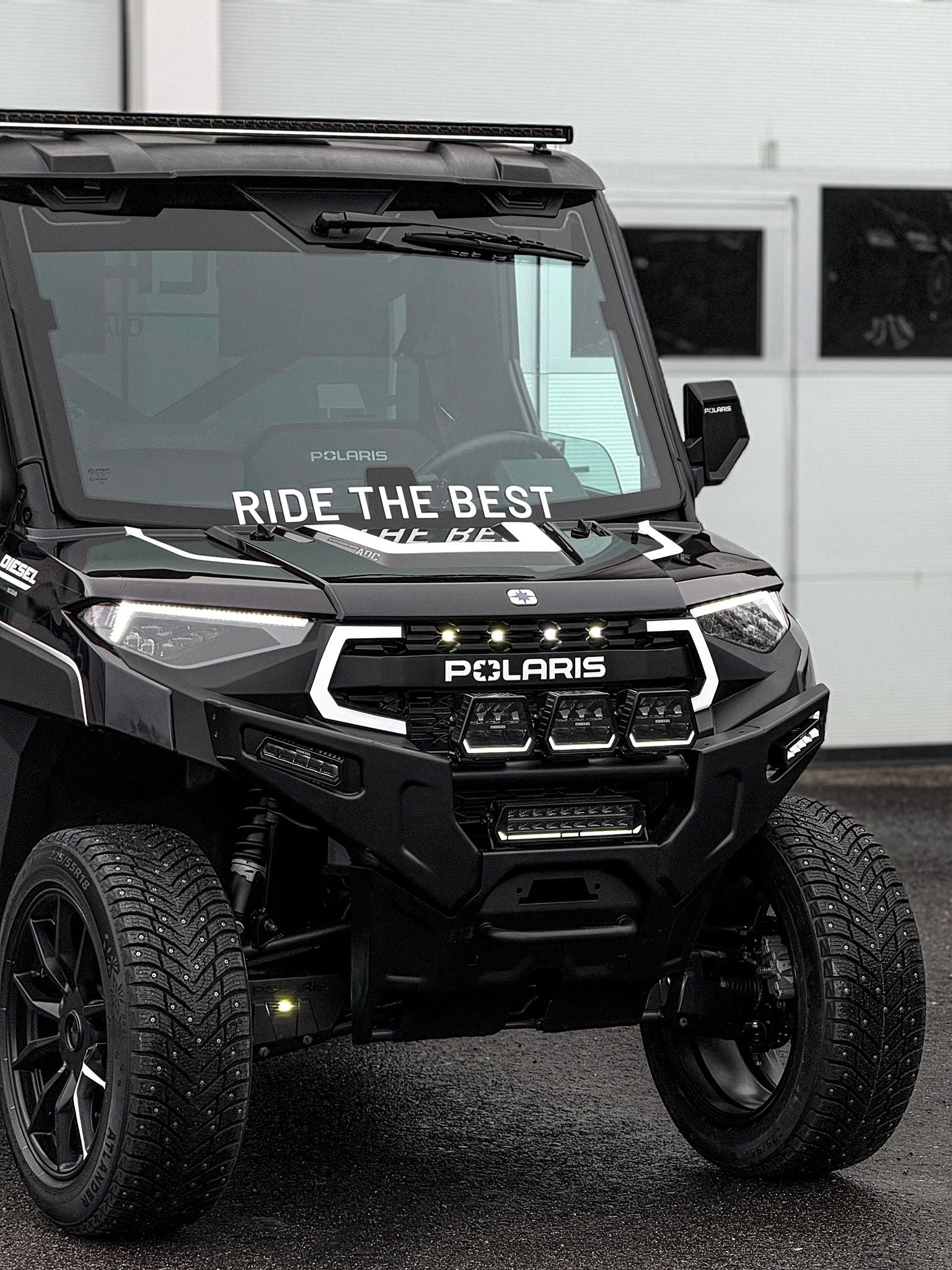 Black Polaris vehicle with 'Ride the Best' decal in a garage setting
